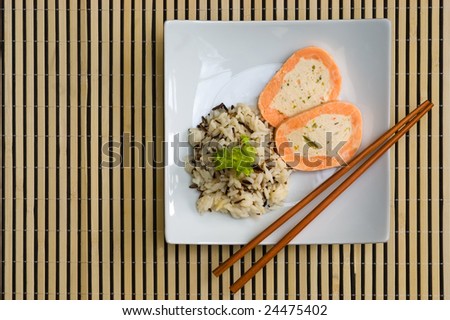 Plate of wild rice with salmon roulade on a bamboo mat
