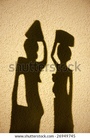 African shadow silhouettes against a plastered wall