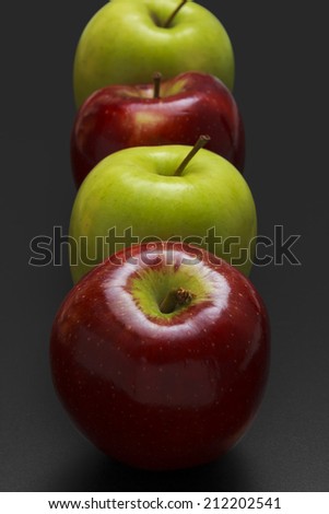 Four apples on black background.