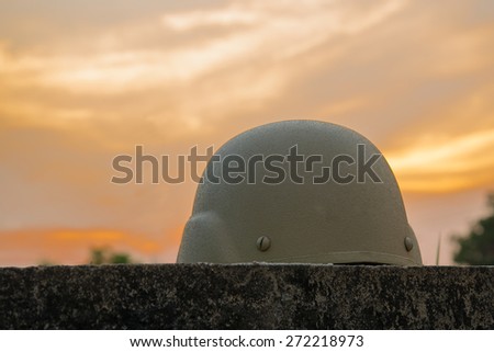 A military helmet of desert camouflage  with gray sunset background