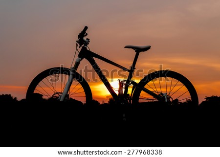 Silhouette shot of full suspension mountain bike on sunset background.