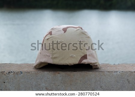A military helmet of desert camouflage  with river background