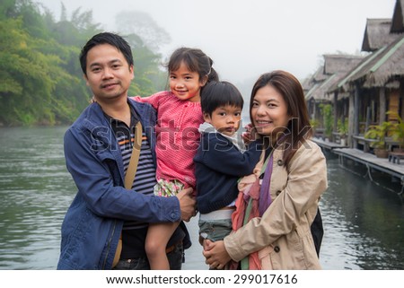 Portrait Of Happy Family spending time together outside in river and Blurred fog background