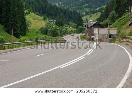 Asphalt road winding through flower hills in Romania