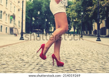 woman legs in red high heel shoes and shorts outdoor shot