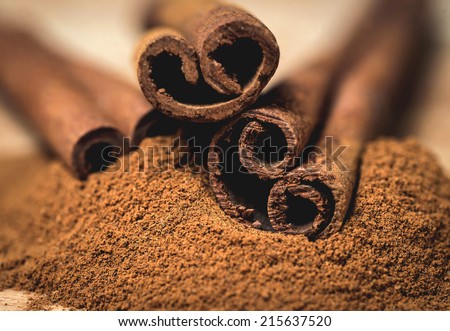 Cinnamon sticks with cinnamon powder on wooden background, Selective focus