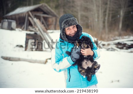 Girl with her cute little dog in the winter forest