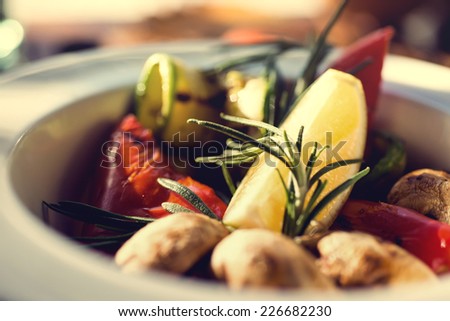 fresh salad with tomatoes, mushrooms, lemon and rosemary on the plate wooden table. Autumn concept