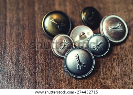Vintage metal buttons with scissors on it.