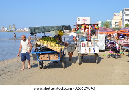 DURRES, ALBANIA - August 30, 2015: Food and fruit merchants pass one after another all day long on the beach of Durres. Albania has two faces - backwardness and poverty versus the new modern life.