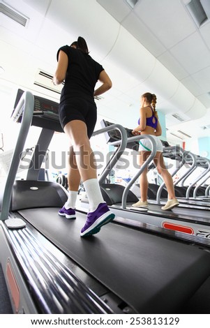 Group of women doing cardio exercises, running on treadmills in the gym