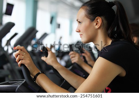 Young woman doing indoor biking in a fitness club