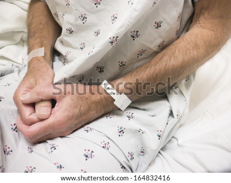 Male hospital patient wearing gown and ID bracelet