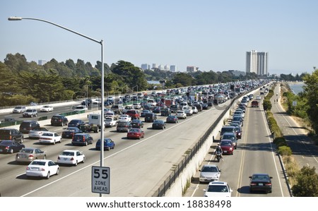 Busy freeway to large city, showing traffic congestion. All logos, etc. removed from vehicles.