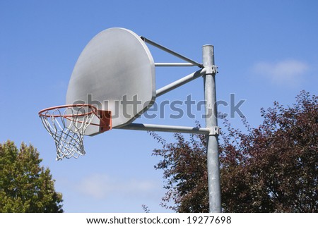 Well used basketball hoop against a clear blue sky