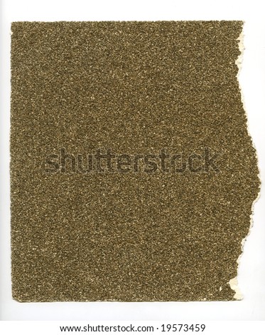 High resolution image of torn piece of coarse sandpaper on a white background.