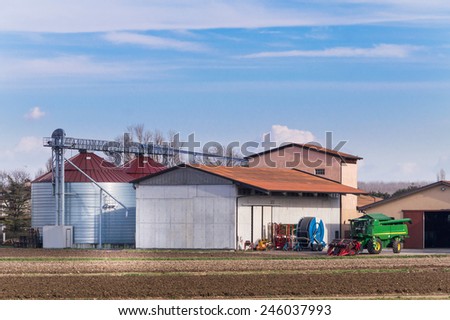 Farm with silos, various agricultural tools and thresher