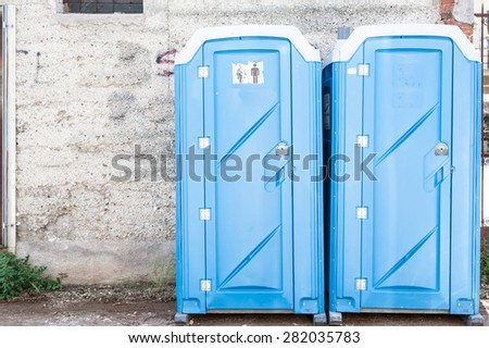 Two blue portable toilet cabins at construction site