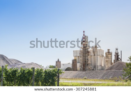 Landscape with cement plant, with vineyards in the foreground
