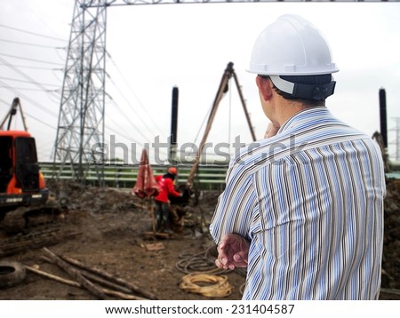 Young engineer looking work in front of construction site
