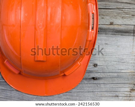 Orange safety hat on wood background