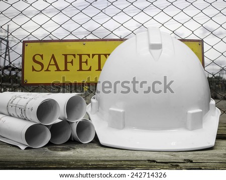 Safety helmet with architectural blueprint of office building over Construction site background