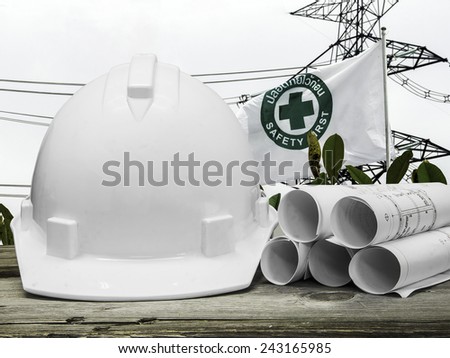 Safety helmet with architectural blueprint of office building over safety sign in Construction site background