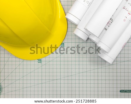 Architectural blueprint of office building with a Safety hat on cutting mat