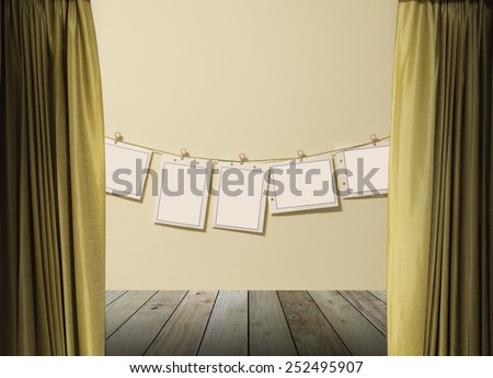 gold curtains on pink wall texture background with paper hanging over pink wall concrete wooden paving.