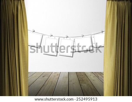 gold curtains on white wall texture background with paper hanging over wall concrete and wooden paving.