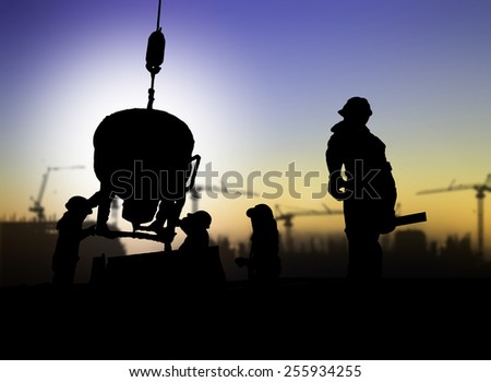 silhouette of engineer and construction worker on scaffold in a building site over Blurred construction site