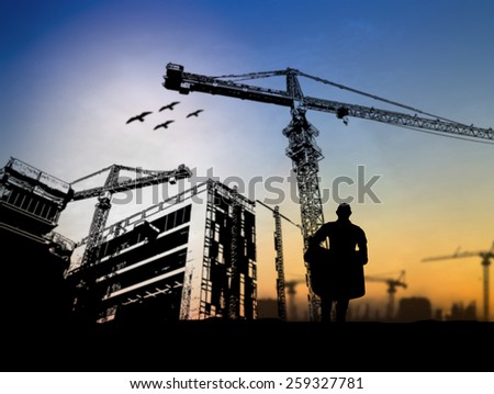 silhouette engineer looking at blueprints in a building site over Blurred construction