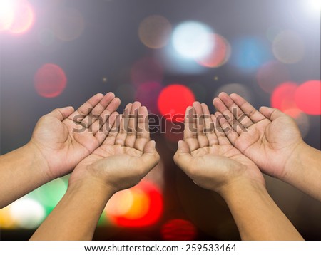 Human open empty hands with palms up over blurred bokeh background