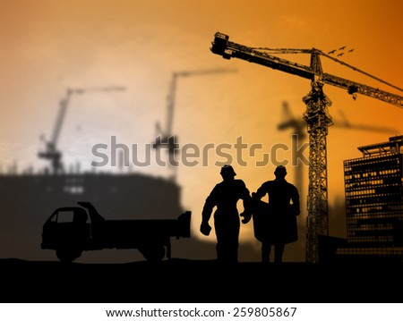 silhouette engineer looking at blueprints in a building site over Blurred construction site