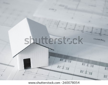 Home model over blurred  architectural blueprint of office building
