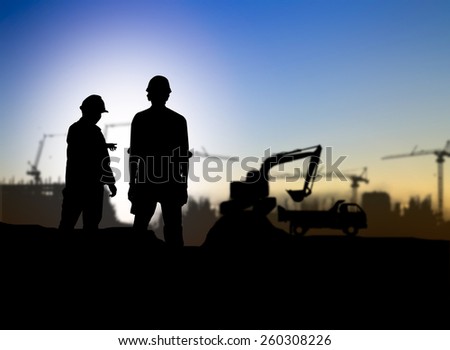 silhouette man engineer looking Loaders and trucks in a building site over Blurred construction worker on construction site