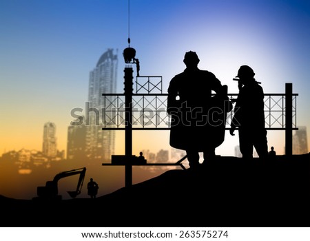 silhouette engineer looking blueprint in a building site over Blurred construction worker on construction site