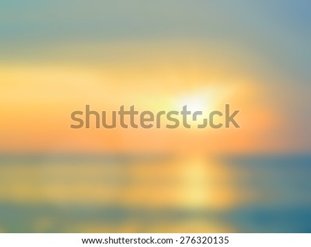 Blurred nature background. Sandy beach backdrop with turquoise water and bright sun light. Summer holidays concept.