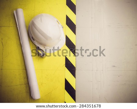 safety hat and blueprint on the factory Floor