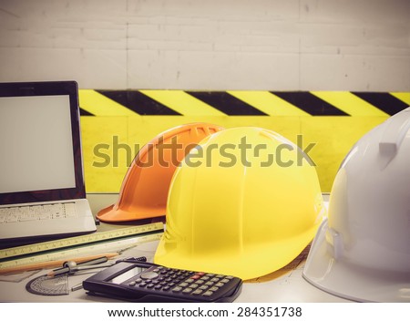 safety hat and blueprint over the factory Floor