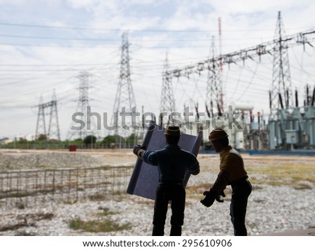 silhouette of engineers over blurred standing at electricity station