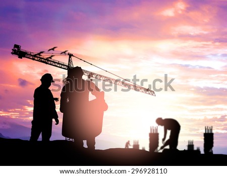 Silhouette man engineer looking construction worker under tower crane in a building site over Blurred construction worker on construction site