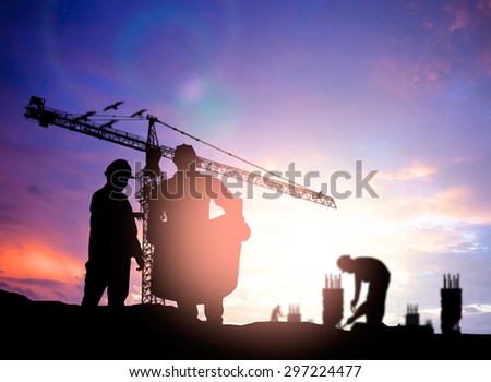 Silhouette man engineer looking construction worker under tower crane in a building site over Blurred construction worker on construction site