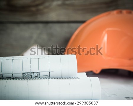 Blueprint of office building over blurred Safety orange hat and blueprint