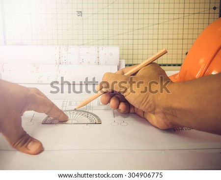 Young Handsome engineer using work tablet to do his work at desk in site office