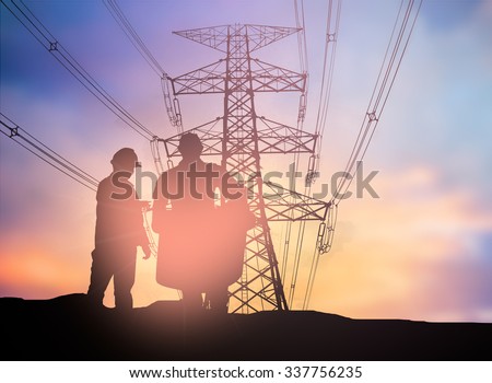 silhouette engineer looking  a building site over Blurred  high voltage transmission towers.