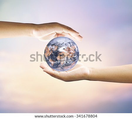 Human hand holding medium green plant with soil on blurred abstract. Ecology, World Environment, Tree of Knowledge concept.Elements of image (like cloud map, world map, etc) are furnished by NASA