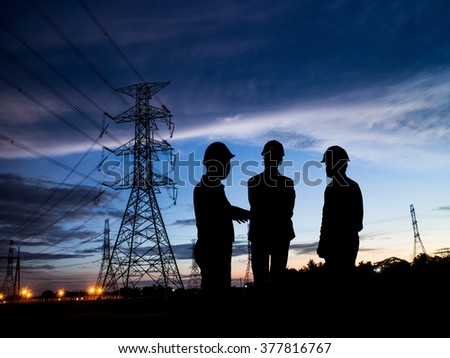 silhouette man of engineers standing at electricity station over Blurred electricity power