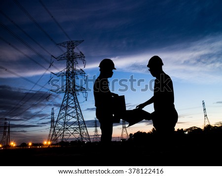 silhouette man of engineers standing at electricity station over Blurred electricity power