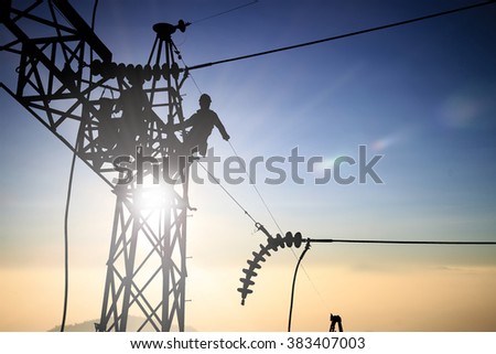 Silhouetteblack man  electrical engineer and electrical workers are installing high voltage systems over blur night city